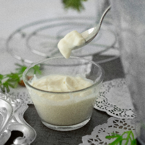 a glass dish of mayonaise being spooned out