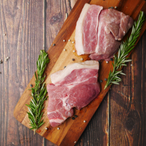 two pieces of raw pork on a cutting board